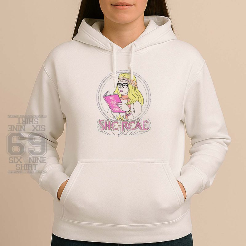 Illustrated “She-Read” design of a retro blonde woman reading a book titled “You Have the Power” in pink, feminist and book-themed apparel