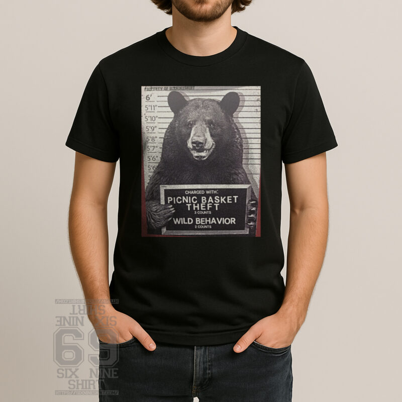 Funny T-shirt featuring a bear mugshot holding a sign that reads ‘Picnic Basket Theft’ and ‘Wild Behavior’ in a vintage police lineup style